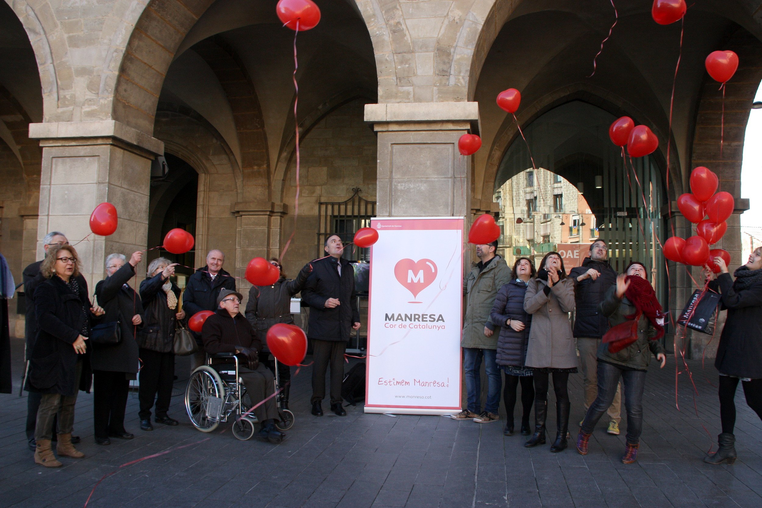 Diferents personen enlairen globus amb forma de cor al costat de la nova imatge 'Manresa, cor de Catalunya' 